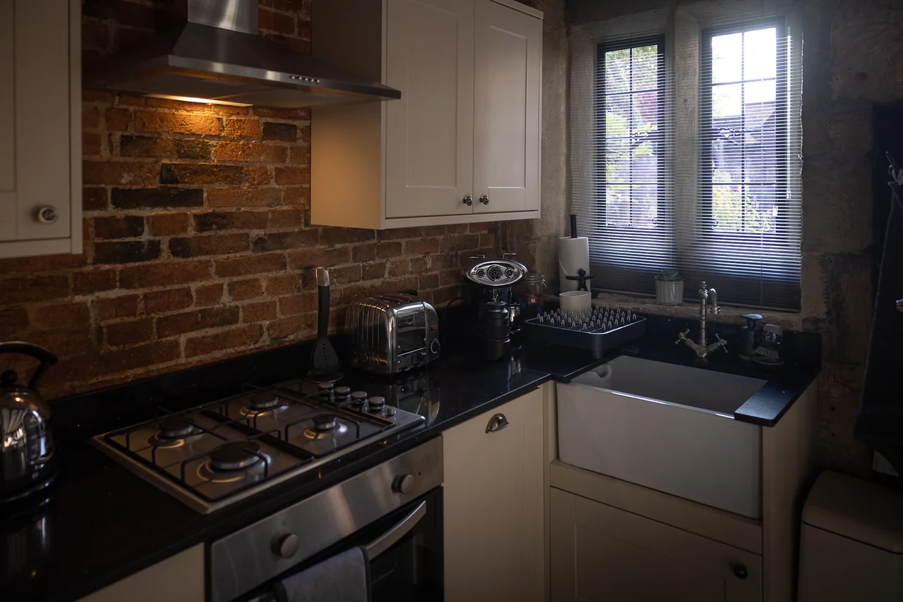 Kitchen with stone walls and garden window at 42 Church Street