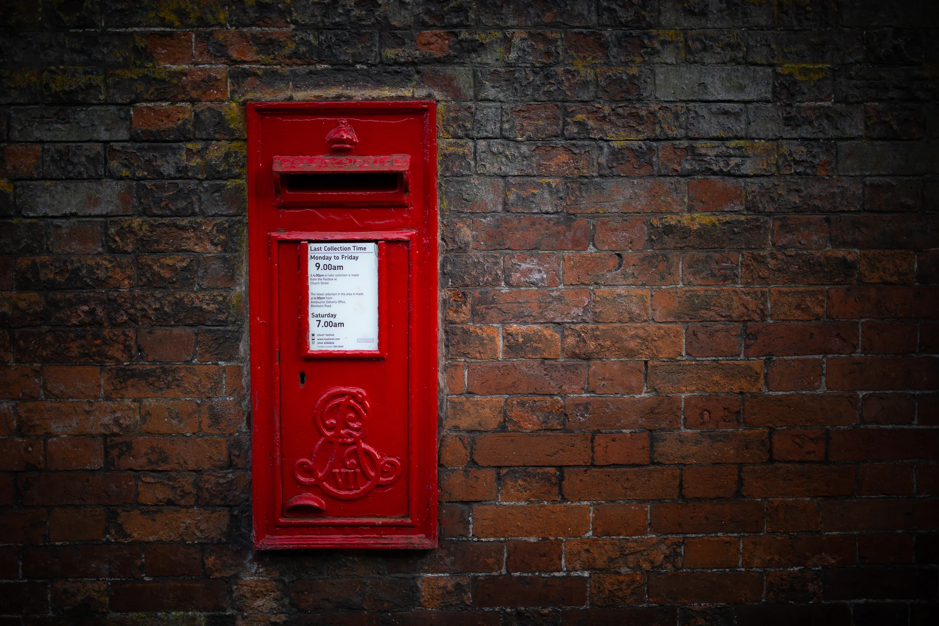 Red postbox set into an Ashbourne brick wall